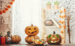 halloween decorations, pumpkin, and candy bowl on table
