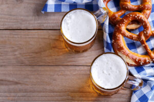 Two pints of beer and pretzels on a blue table cloth, Octoberfest snack