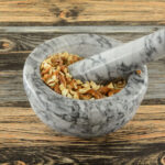 Pretzels being crushed up in a mortar and pestle.