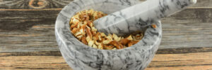 Pretzels being crushed up in a mortar and pestle.