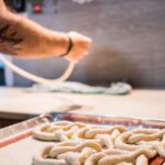 A man shaping pretzels into their classic twisted shape