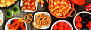 An assortment of fall and Halloween candies with a bowl of pretzels